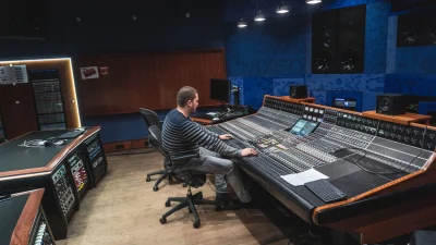 Audio engineer working at a large studio console, illustrating what is mixing vs mastering in a professional sound environment.