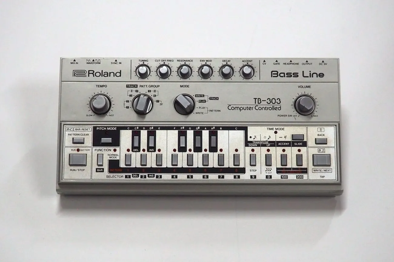 Roland TB-303 bass synthesizer known for its iconic acid house basslines, featuring knobs, buttons, and a small keyboard.