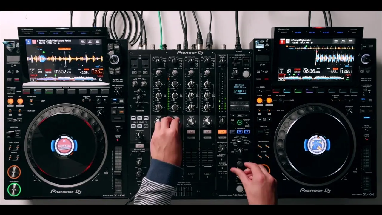 Hands adjusting controls on a Pioneer DJ setup with two CDJ-3000 players and a DJM-900 mixer during a tech house mix.